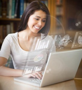 Smiling student analysing graphs on her digital laptop in university library